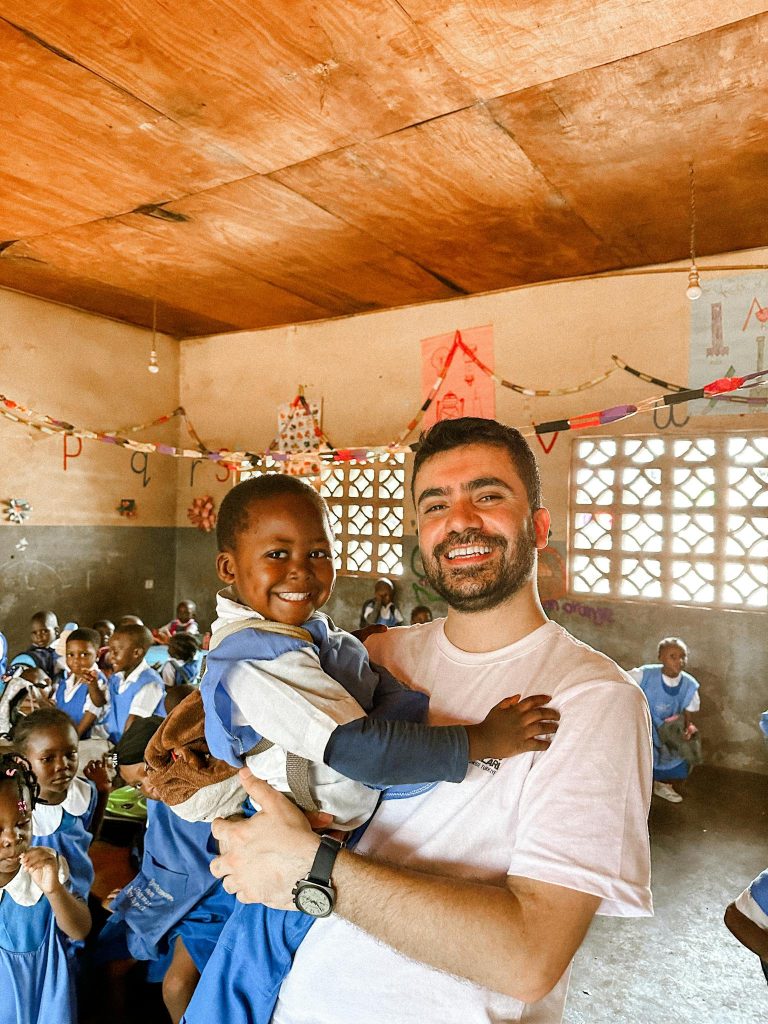 Smiling teacher and student in a lively classroom, embracing education joy.